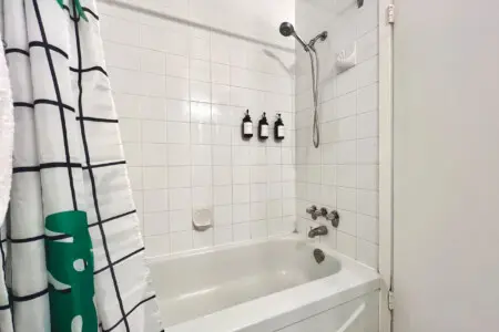 A clean, modern bathtub and shower setup complete with essential toiletries — perfect for refreshing mornings or unwinding after a day exploring Vancouver.