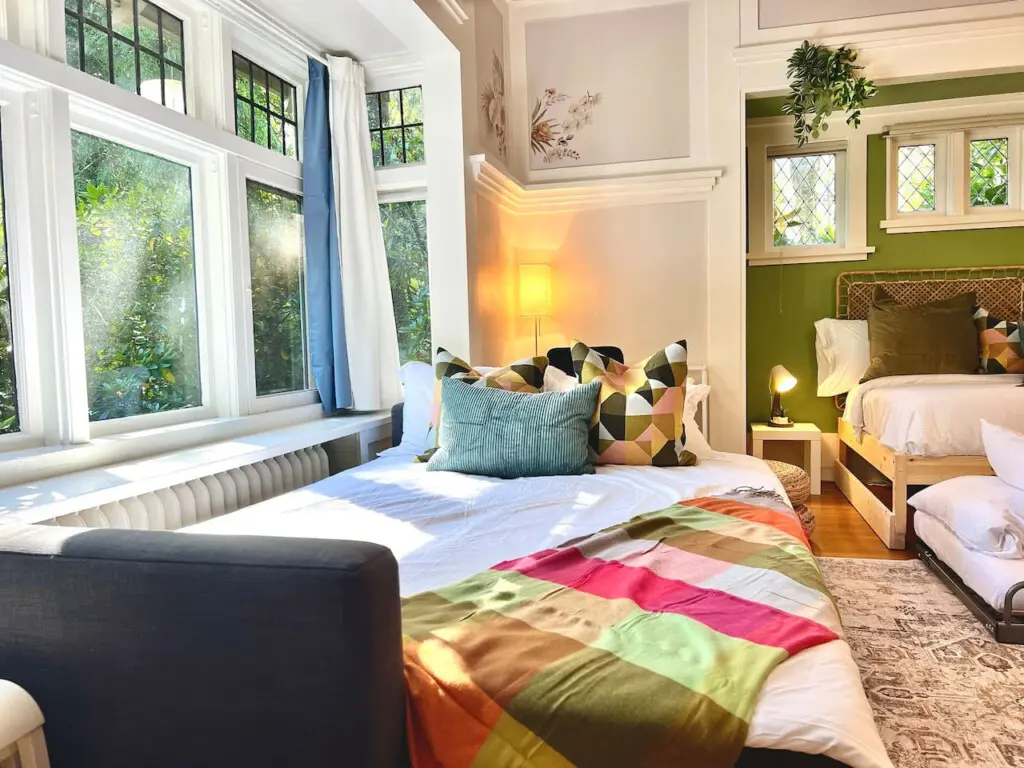 Sunlight fills this cozy corner, creating a warm and restful space for relaxation. Perfect for families or friends, the thoughtfully arranged beds offer both comfort and style in this inviting Vancouver suite.