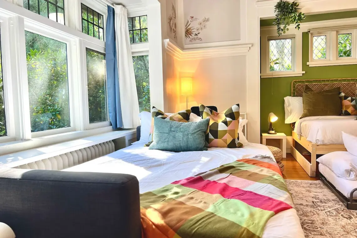 Sunlight fills this cozy corner, creating a warm and restful space for relaxation. Perfect for families or friends, the thoughtfully arranged beds offer both comfort and style in this inviting Vancouver suite.