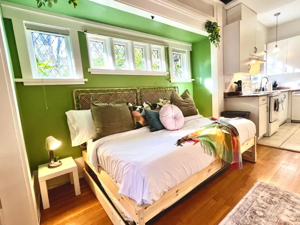 Warm sunlight and soft tones fill this cozy bedroom nook, creating a peaceful retreat beside the kitchen. A perfect blend of comfort and modern charm for a relaxing Vancouver stay.