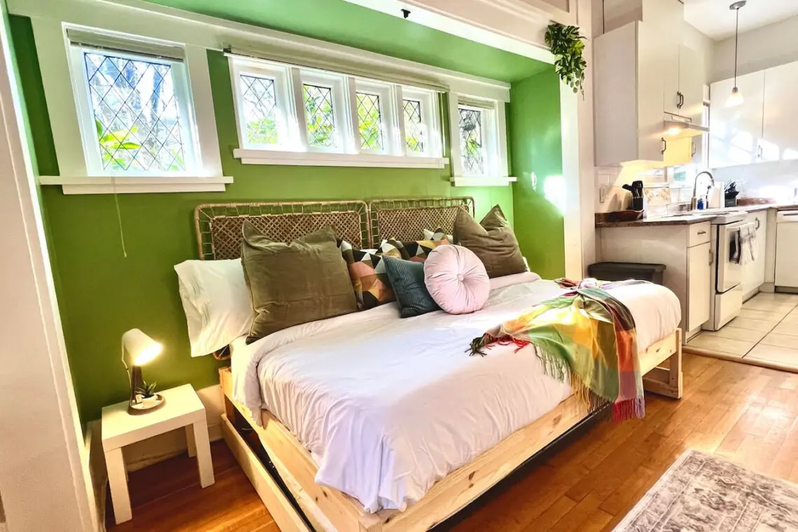 Warm sunlight and soft tones fill this cozy bedroom nook, creating a peaceful retreat beside the kitchen. A perfect blend of comfort and modern charm for a relaxing Vancouver stay.