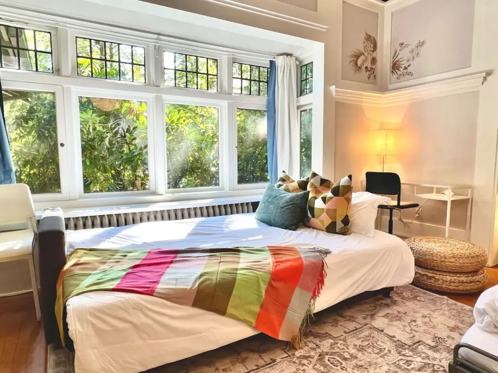 Sunlight streams through large windows, creating a bright and welcoming space to unwind. Perfect for lounging or an afternoon nap during your Vancouver stay.