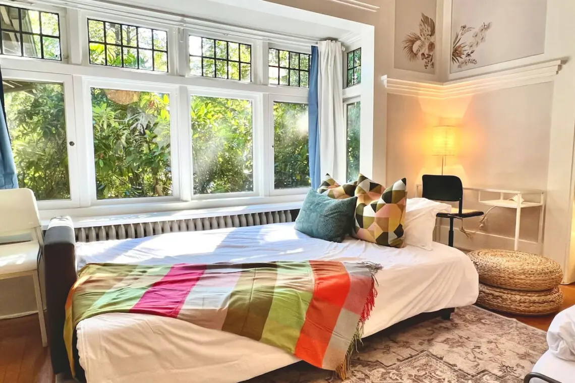 Sunlight streams through large windows, creating a bright and welcoming space to unwind. Perfect for lounging or an afternoon nap during your Vancouver stay.