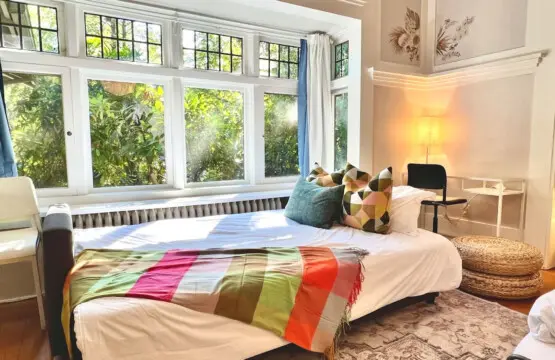 Sunlight streams through large windows, creating a bright and welcoming space to unwind. Perfect for lounging or an afternoon nap during your Vancouver stay.