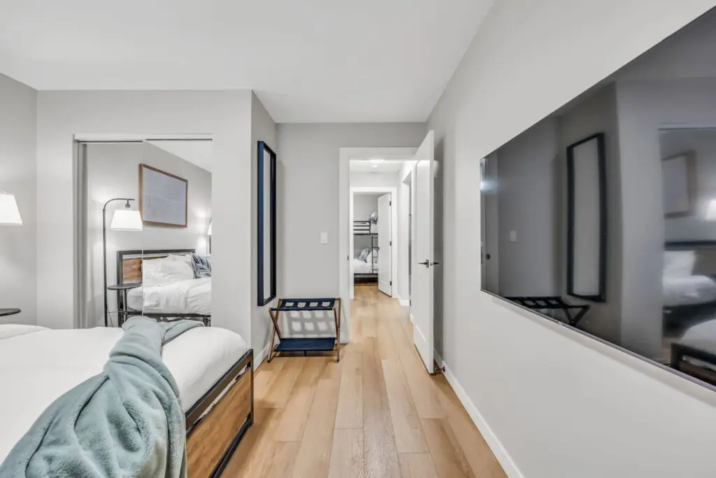 A bright and inviting bedroom featuring a sleek TV and cozy ambiance — the perfect space to unwind and recharge in comfort.