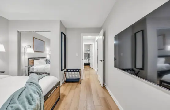 A bright and inviting bedroom featuring a sleek TV and cozy ambiance — the perfect space to unwind and recharge in comfort.