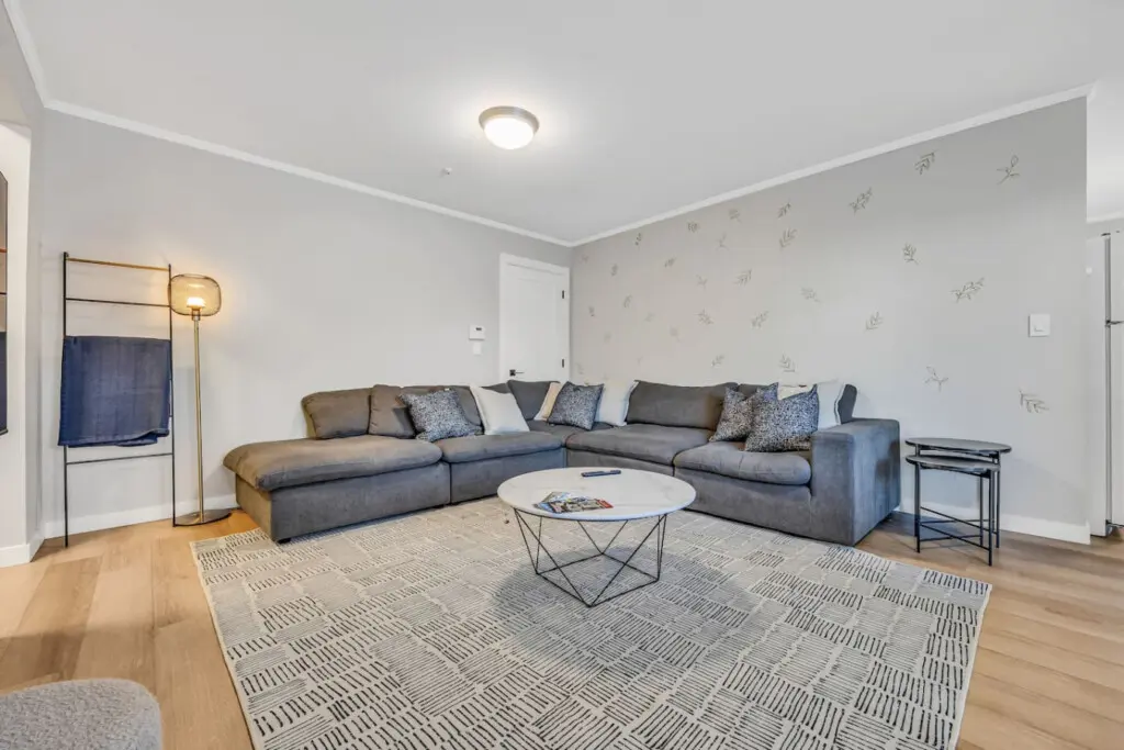 A cozy corner designed for family gatherings, featuring a spacious sectional sofa, warm lighting, and modern décor — the perfect space to relax, chat, or enjoy a quiet evening together.