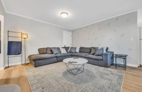 A cozy corner designed for family gatherings, featuring a spacious sectional sofa, warm lighting, and modern décor — the perfect space to relax, chat, or enjoy a quiet evening together.