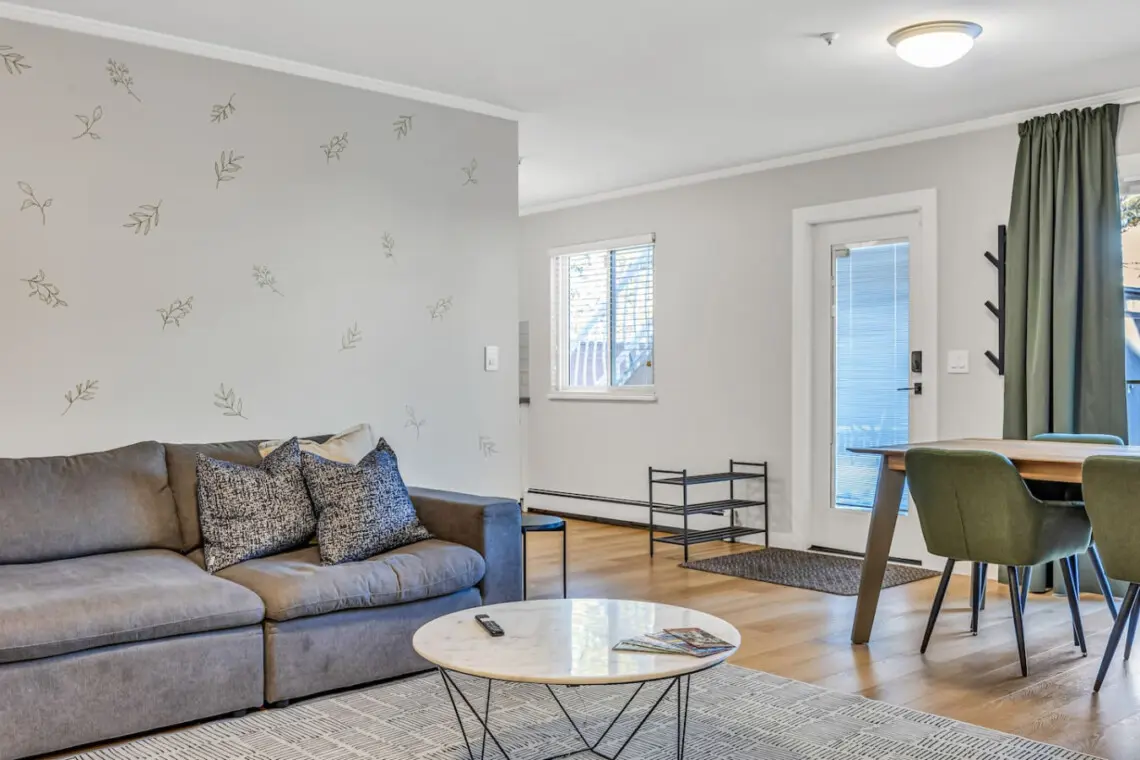 Modern living space featuring a cozy sofa, stylish décor, and a sleek dining area — perfect for relaxing, sharing meals, or enjoying quality time with family and friends.