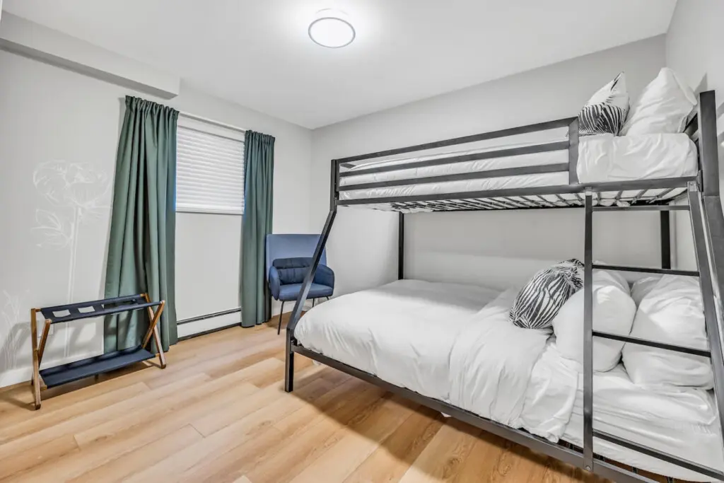 Rest easy in this cozy bedroom featuring plush bunk beds — perfect for families or groups to unwind after a full day of Vancouver adventures.