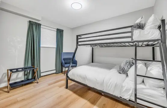 Rest easy in this cozy bedroom featuring plush bunk beds — perfect for families or groups to unwind after a full day of Vancouver adventures.