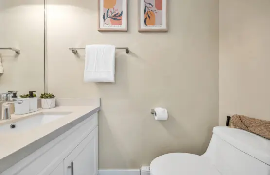 Powder bathroom on the 1st floor equipped with a clean sink, mirror, and toilet for your comfort.