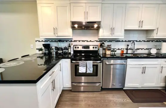 This modern kitchen features a spacious countertop perfect for meal prep, casual dining, or gathering with friends — complete with stainless steel appliances and sleek finishes for a contemporary touch.