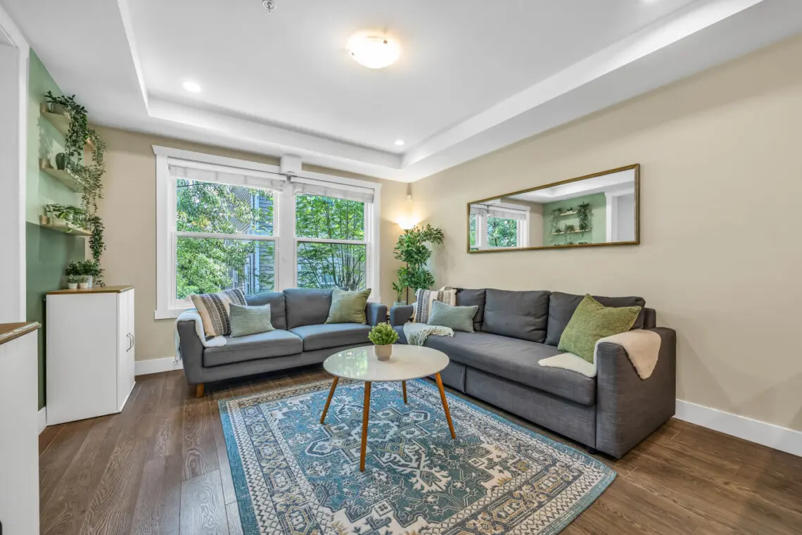 Bright and spacious living room featuring cozy seating and large windows that fill the space with natural light—perfect for relaxing, socializing, or enjoying quiet moments with family and friends.