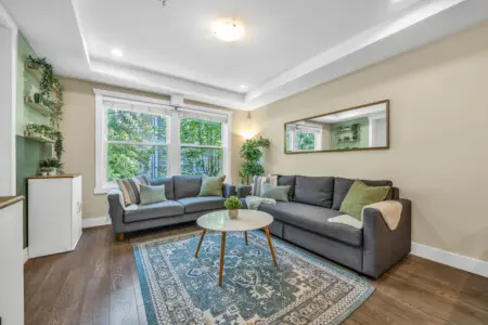 Bright and spacious living room featuring cozy seating and large windows that fill the space with natural light—perfect for relaxing, socializing, or enjoying quiet moments with family and friends.