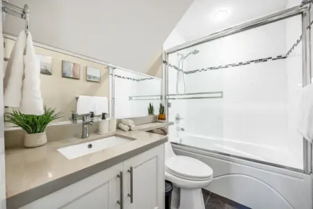 Bright and spotless ensuite bathroom for Bedroom 1, featuring a bathtub and toilet for added comfort — conveniently located on the first floor, just off the King Bedroom.