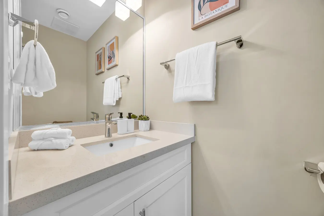 Powder bathroom on the first floor, off of the main hallway near the living room - equipped with a clean sink, mirror, and toilet for your comfort.