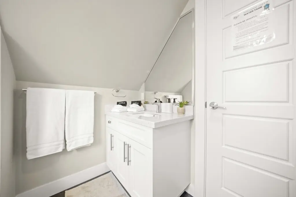 Tucked beneath the eaves, this bright and modern full bathroom offers a peaceful space to refresh and unwind. Crisp white finishes, soft towels, and thoughtful touches create a calm, spa-like atmosphere within this beautifully designed Vancouver stay.