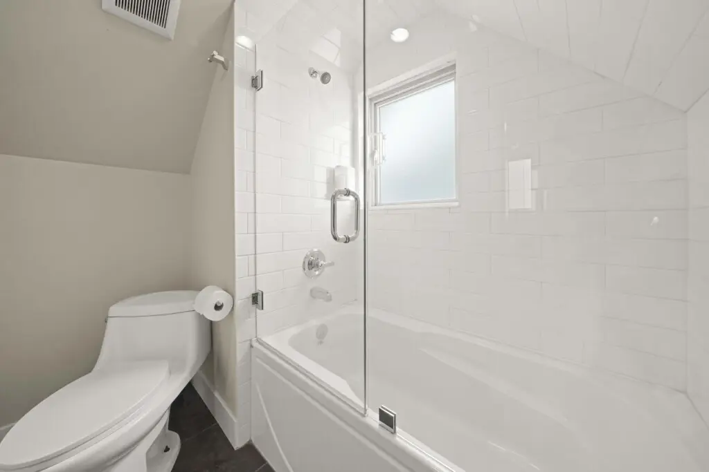 This bright third-floor bathroom features a sleek, glass-enclosed shower-tub combo and crisp modern finishes. With soft lighting and clean design, it provides a refreshing space for guests to relax and recharge in comfort.