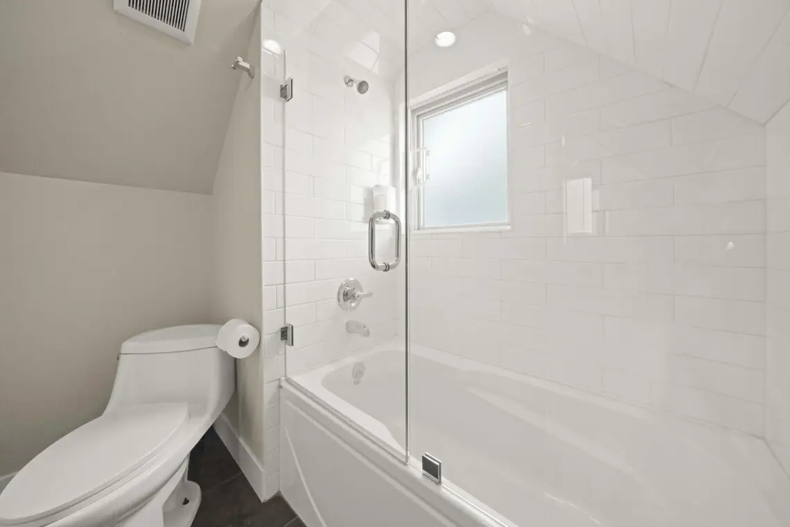 This bright third-floor bathroom features a sleek, glass-enclosed shower-tub combo and crisp modern finishes. With soft lighting and clean design, it provides a refreshing space for guests to relax and recharge in comfort.