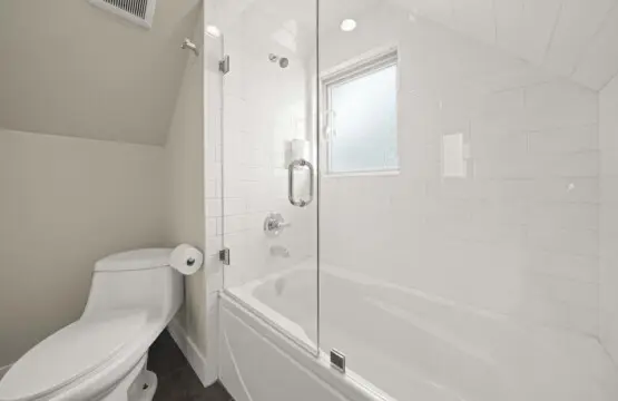 This bright third-floor bathroom features a sleek, glass-enclosed shower-tub combo and crisp modern finishes. With soft lighting and clean design, it provides a refreshing space for guests to relax and recharge in comfort.