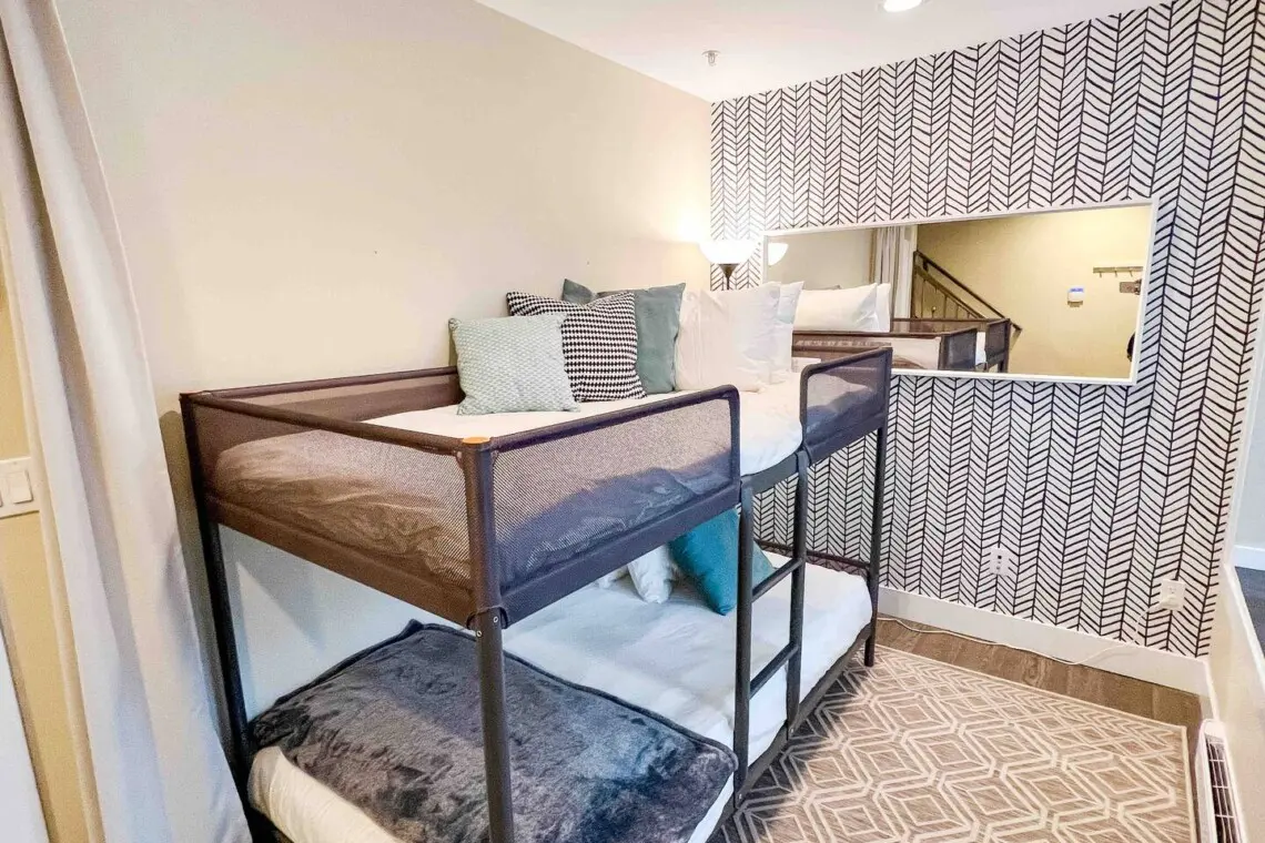 Located on the first floor, this cozy den features twin bunk beds and a calm, modern design. Soft textures and natural light create a peaceful space for rest or quiet relaxation.