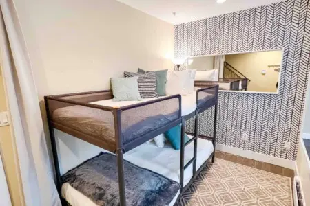 Located on the first floor, this cozy den features twin bunk beds and a calm, modern design. Soft textures and natural light create a peaceful space for rest or quiet relaxation.