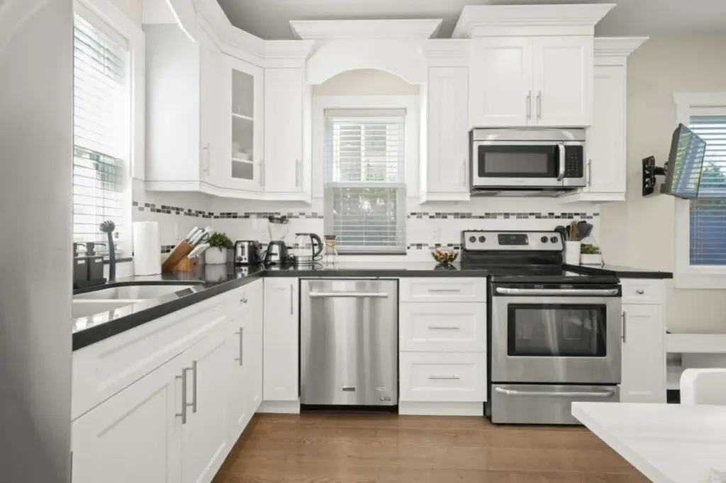 This bright, modern kitchen features stainless-steel appliances and ample counter space. Perfect for cooking, connecting, and sharing meals in a welcoming open-concept setting.
