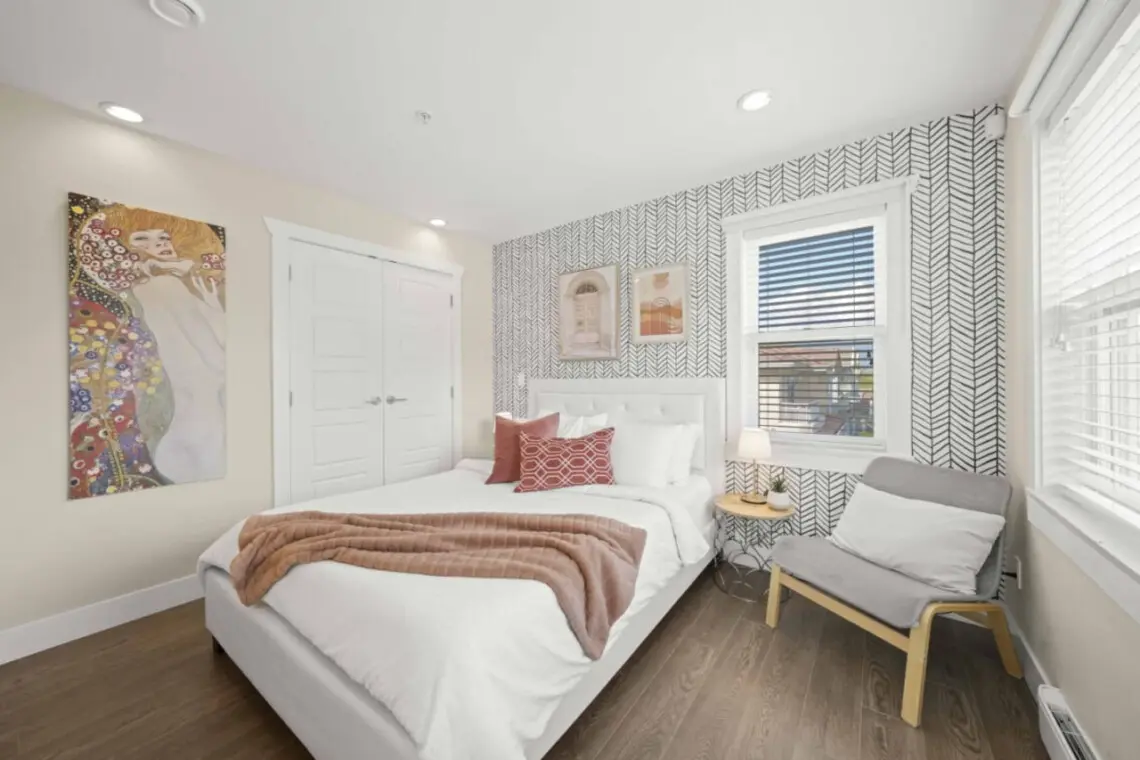 Tranquil Retreat — the second bedroom offers a plush queen bed, blackout blinds, and soft linens for restful sleep. Filled with natural light by day and calm ambiance by night, it’s the ideal space to unwind and recharge.