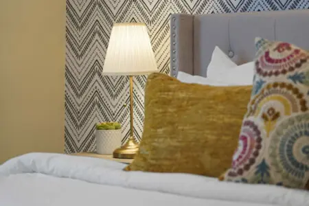 Elegant details bring warmth and charm to the primary bedroom, from the soft bedding and textured pillows to the gentle glow of the bedside lamp. Thoughtfully designed, it offers a cozy and refined space to unwind and recharge.