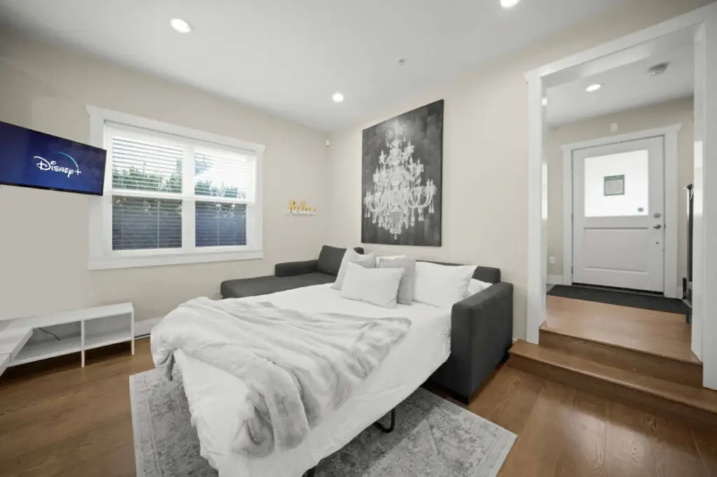 Stylish and functional — the cozy living area features a sectional that transforms into a double bed, perfect for extra guests. After a day exploring Vancouver, unwind with a movie on Disney+ and enjoy the inviting, relaxed atmosphere of this modern space