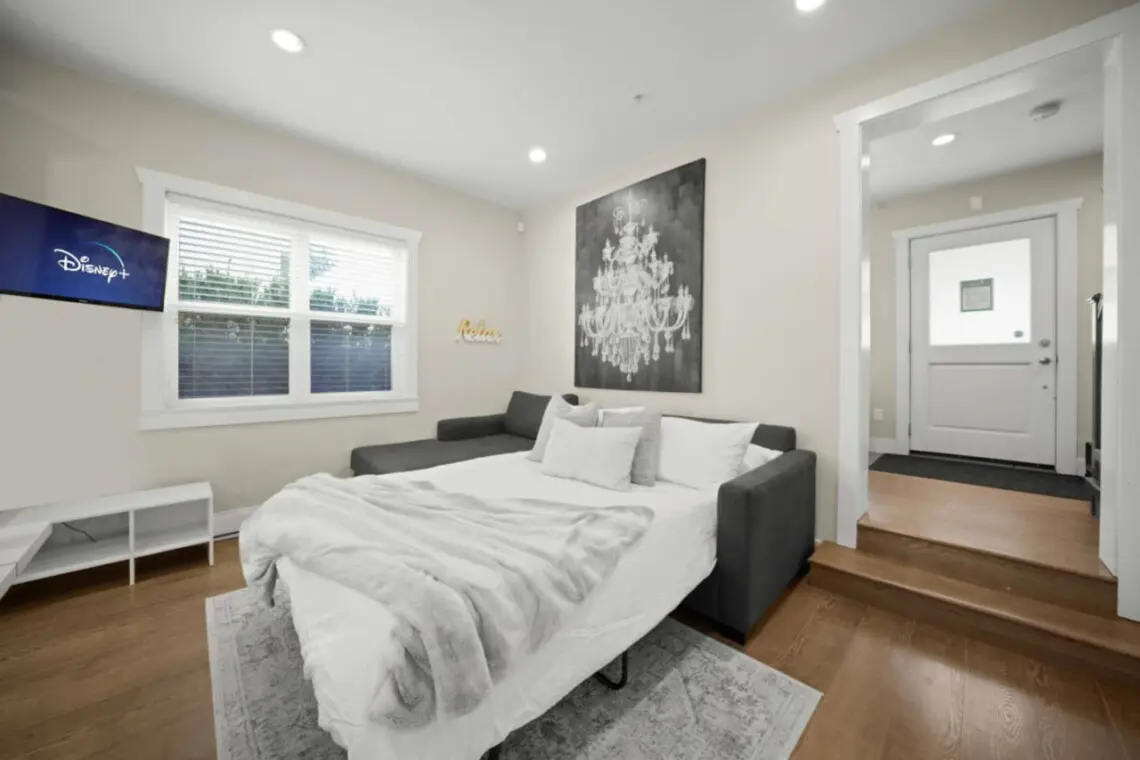 Stylish and functional — the cozy living area features a sectional that transforms into a double bed, perfect for extra guests. After a day exploring Vancouver, unwind with a movie on Disney+ and enjoy the inviting, relaxed atmosphere of this modern space