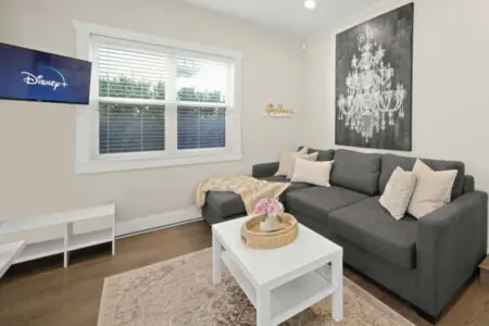 Cozy living area featuring a plush sectional sofa — perfect for relaxing after a day of exploring. Enjoy your favorite shows and movies on the smart TV equipped with Disney+, Netflix, Crave, and Amazon Prime for endless entertainment options.