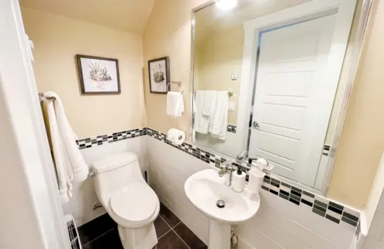The main floor bathroom features a clean, modern design accented with soft lighting and tasteful decor. Thoughtfully stocked with essentials, it offers both comfort and convenience — a refreshing retreat within your furnished Vancouver suite.