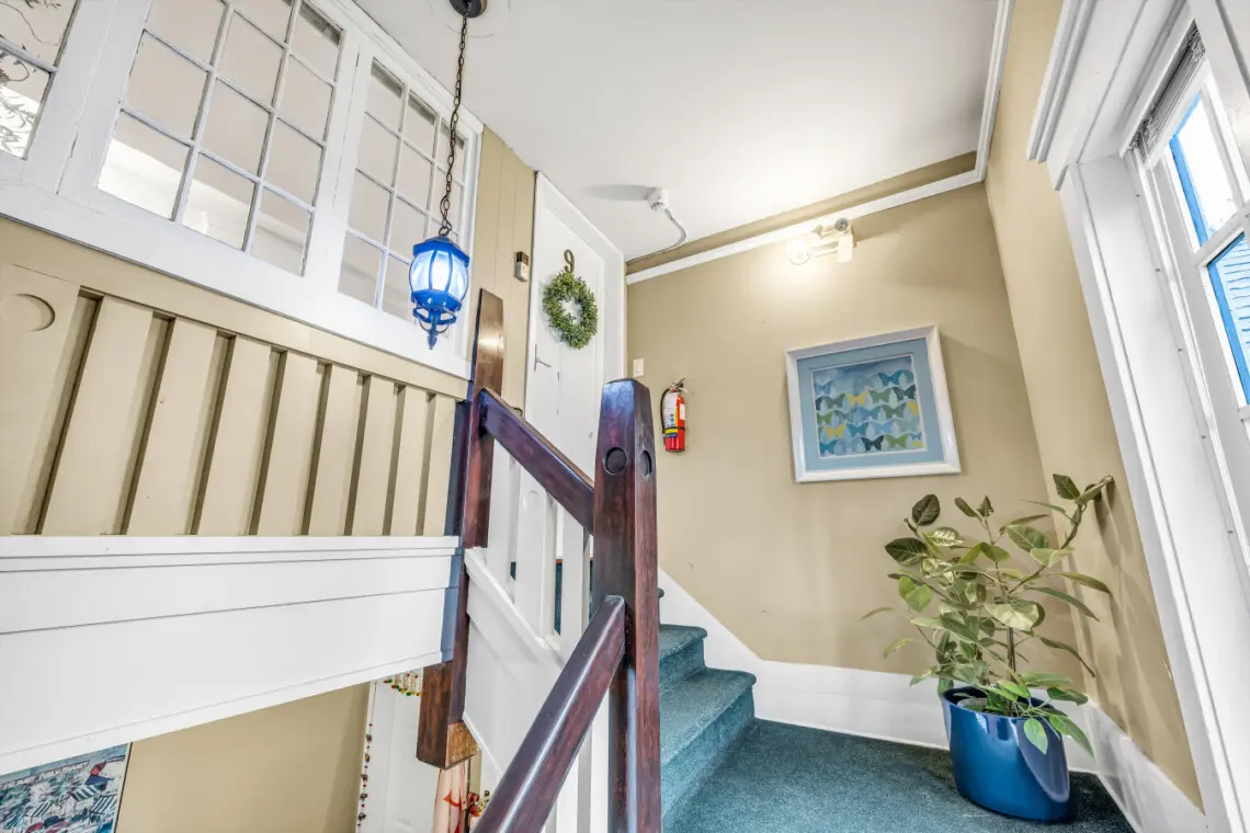 Charming stair landing with warm natural light, classic wood railings, and thoughtful decor accents creating a welcoming transition between spaces.
