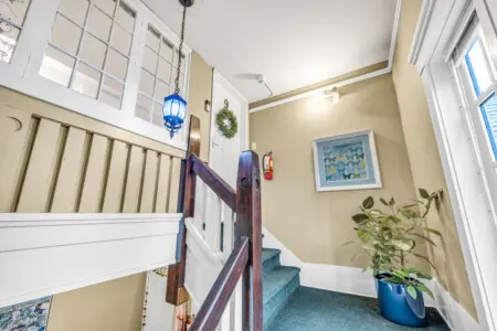 Charming stair landing with warm natural light, classic wood railings, and thoughtful decor accents creating a welcoming transition between spaces.