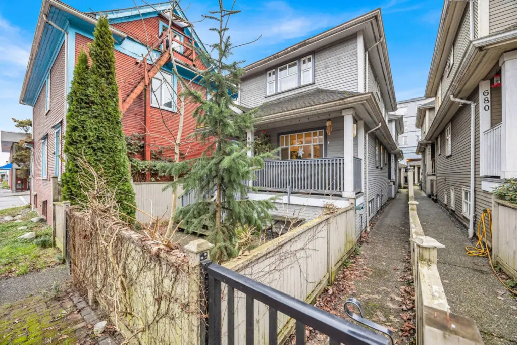 Charming exterior view showcasing a quaint house with a front porch, surrounded by greenery and an inviting walkway leading to the entrance.