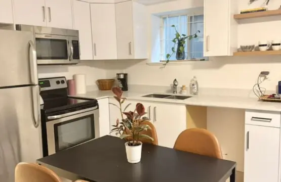 Modern kitchen with sleek appliances, open shelving, and a cozy dining nook, perfect for enjoying meals in a bright and airy space.