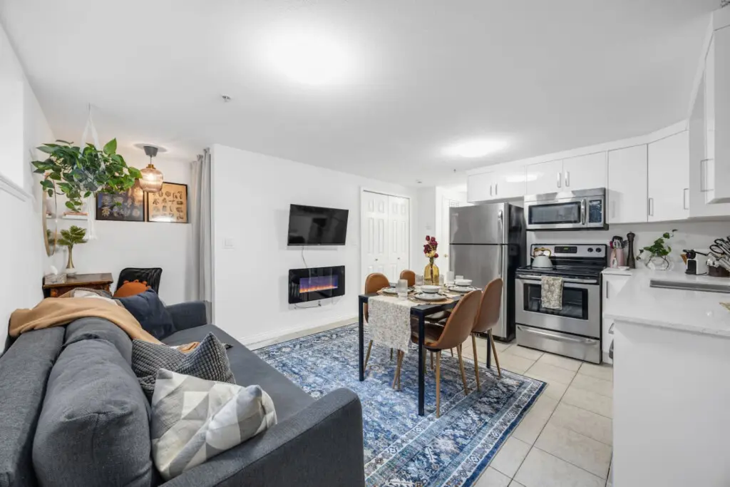 Serene bedroom with a comfortable bed, soft textured pillows, and a calming green wall, creating a peaceful retreat enhanced by vibrant orange curtains.