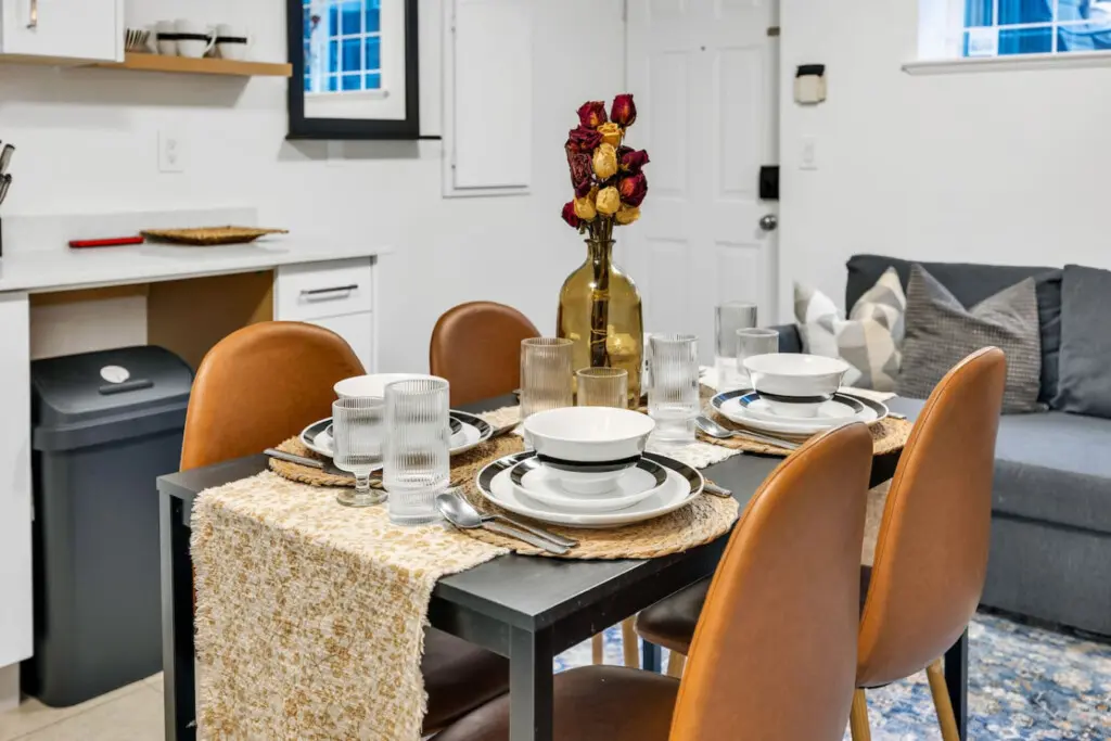 Stylish dining area with a modern table set for four, complemented by cozy seating and elegant décor, perfect for enjoying meals together.