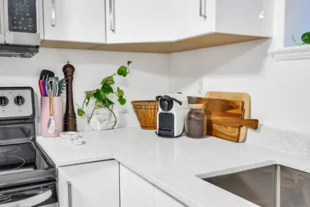 Clean and functional kitchen corner with modern appliances, wooden cutting boards, and decorative touches, offering both style and practicality.