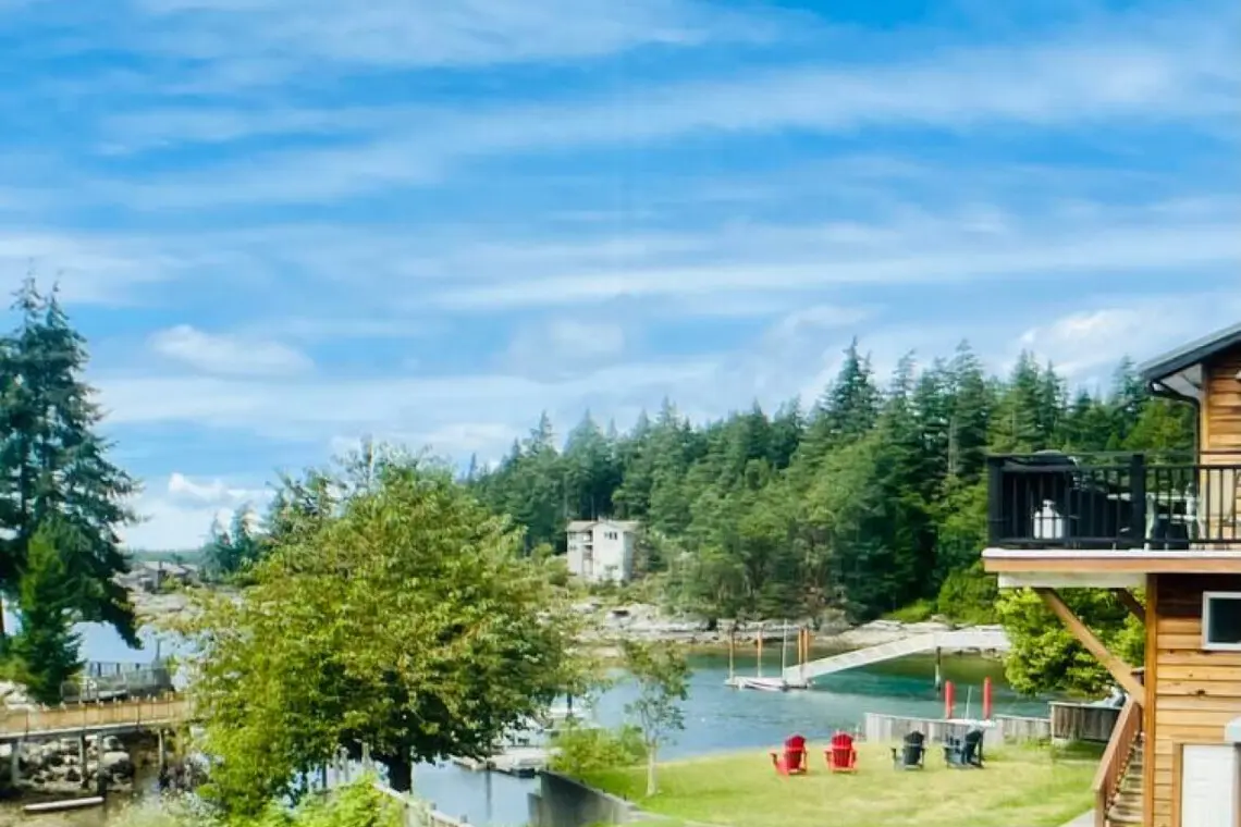 Scenic view of the lush landscape, tranquil waterfront, and a cozy seating area, offering a peaceful retreat surrounded by nature.