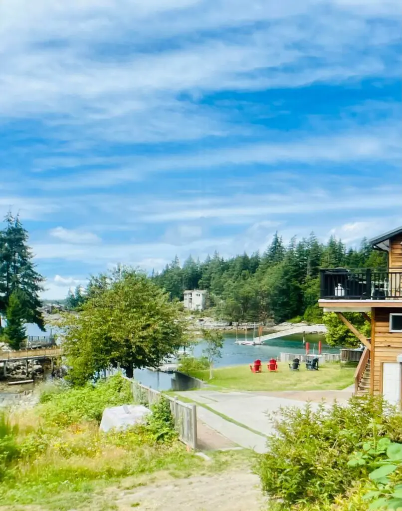 Scenic view of the lush landscape, tranquil waterfront, and a cozy seating area, offering a peaceful retreat surrounded by nature.