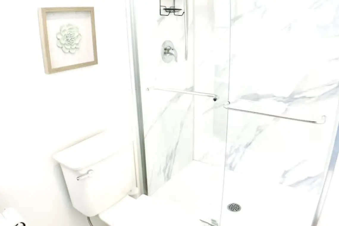 "Bright and airy bathroom with a spacious glass shower, clean lines, and minimalist decor for a refreshing and comfortable experience.