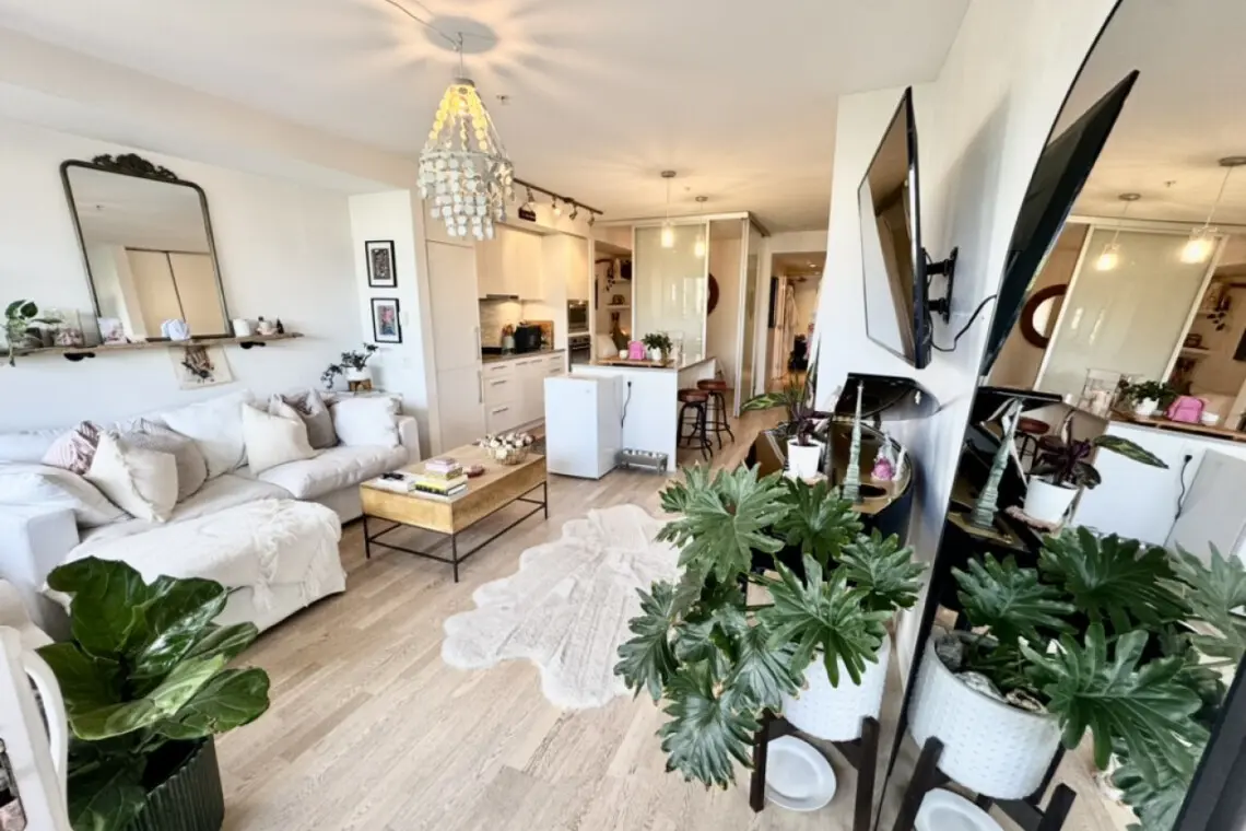 Bright and airy living space with modern touches, plenty of greenery, and a cozy nook to relax and enjoy the view.