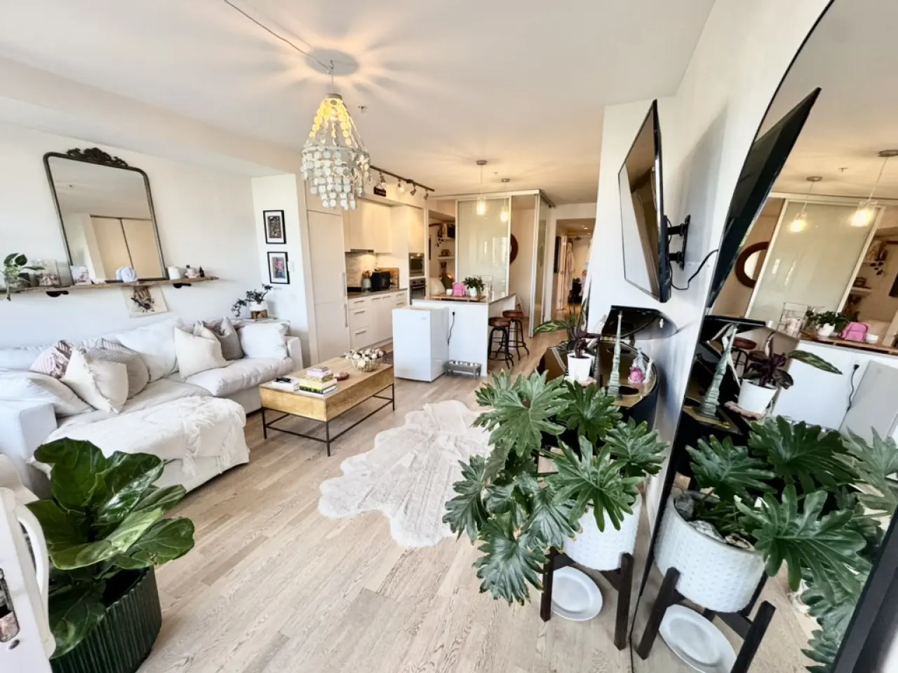 Bright and airy living space with modern touches, plenty of greenery, and a cozy nook to relax and enjoy the view.